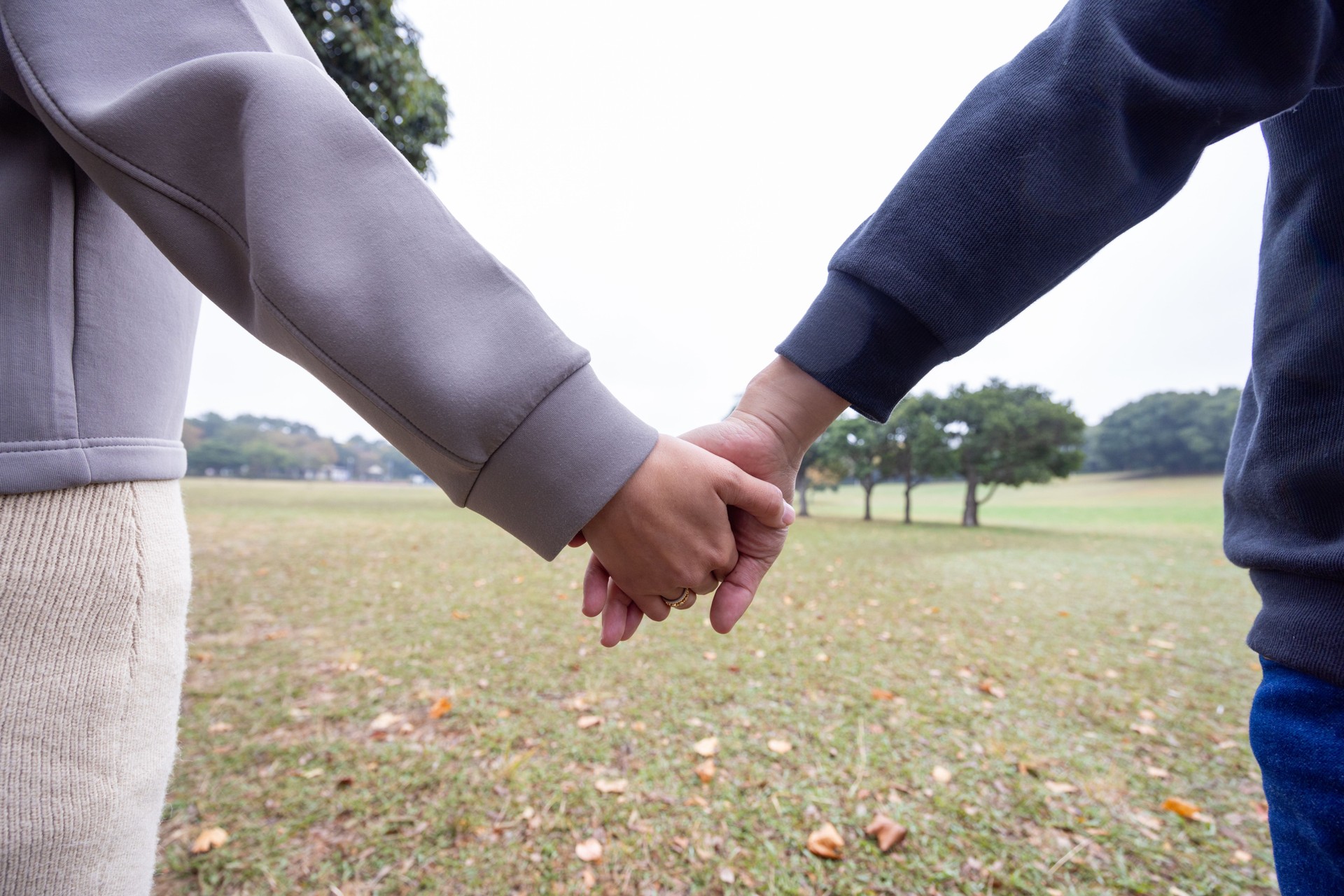 Couple holding hands in public park